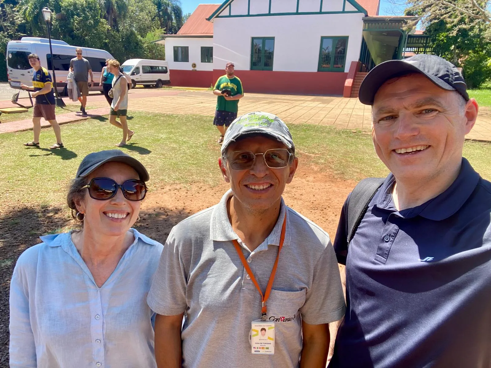 Tour guide Miguel smiling with tourists in front of a charming colonial-style building, indicating a cultural or historical stop on the tour.